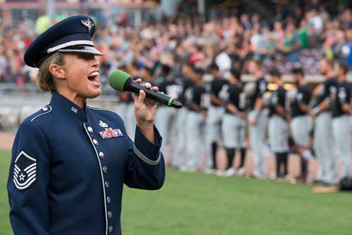 Female officer singing anthem at baseball game
